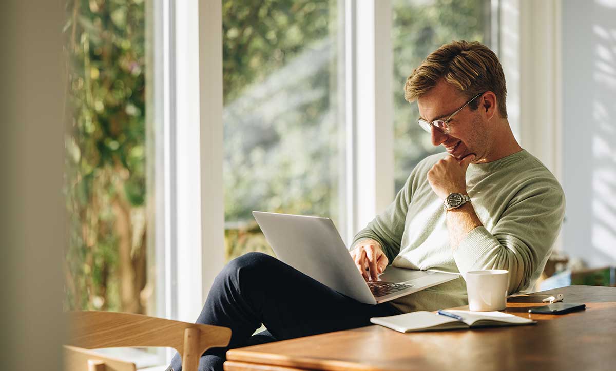 man using laptop and smiling